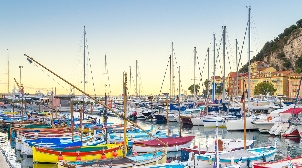 The port of Nice at dawn bursting with colourful boats and yachts